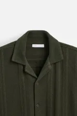 Camisa verde militar de manga corta con cuello bowling, corte relaxed fit y cierre frontal con botones.