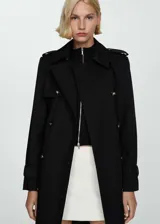 Trench coat negro de algodón con doble botonadura, cuello de solapa, trabillas en hombros y cintura, cinturón desmontable y abertura en la parte posterior del bajo.