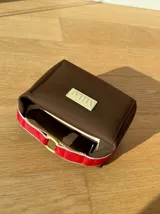 Neceser color beige de forma rectangular, con cierre superior y asa de mano.