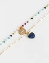 Collar corto dorado con cadena de eslabones y cadena de cuentas de colores. Incluye dije de moneda dorada con estrella grabada y dije de corazón de piedra azul.