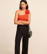 Pantalón de vestir negro de corte recto, con bolsillos laterales y cierre de cremallera lateral. Presenta detalles de hilo metalizado en la trama.