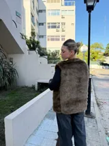 Chaleco marrón de piel sintética con cuello redondo y corte recto.