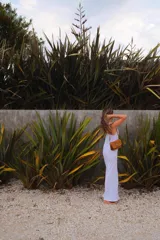 Bolso pequeño tipo bandolera, color camel/marrón claro, con diseño estructurado tipo acordeón y correa ajustable.