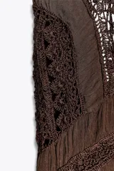 Vestido largo color marrón con detalle de crochet en el corpiño, escote redondo y manga corta. Cierre en la espalda con lazadas.