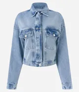 Campera de jean celeste, corte cropped y holgado, con cuello camisero, cierre abotonado, mangas largas, bolsillos con solapa en el pecho y recortes verticales.