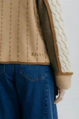 Chaqueta tejida en lana merino y lambswool color negro, con detalles bordados en beige y marrón.