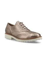 Zapato Oxford color bronce con detalles de perforaciones y suela blanca de goma.