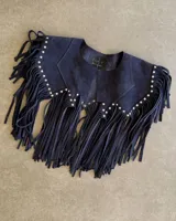 Chaleco corto de cuero vacuno color azul marino con flecos y tachas plateadas.