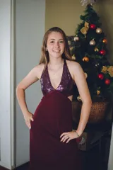 Vestido largo color marrón cobrizo con escote en V, cut outs laterales bajo el busto y breteles finos que se cruzan y atan en la espalda. Presenta un top con estampado abstracto en tonos marrones y dorados.