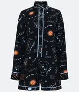 Enterito corto negro con estampado de aliens y texto en blanco y naranja. Tiene cuello camisero, cierre frontal con botones y mangas largas con puños arremangados. Incluye riñonera negra.