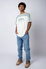 Remera color beige con mangas y parte superior en verde militar. Estampado frontal con texto "Lucky" y diseño de flores con rostro.