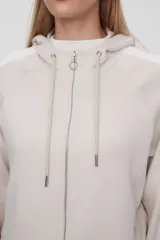 Campera con capucha color beige claro con cierre frontal y bolsillos laterales. Presenta una banda blanca en las mangas. Corte holgado.