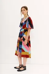 Vestido midi de gasa estampada con diseño geométrico multicolor, mangas cortas y elástico en la cintura. Tiene tajo frontal y forro en la falda.