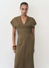 Vestido midi color verde oliva, de tejido fluido y diseño evasé. Presenta escote de pico, mangas cortas, cierre de cremallera invisible en la parte posterior y detalle drapeado en la cintura.