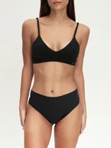 Conjunto de ropa interior negro, compuesto por un corpiño triangular con tirantes finos y una bombacha tipo culotte de cobertura total.