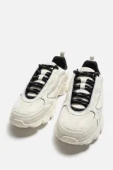 Zapatillas grises con cordones, capellada combinada y suela chunky con diseño irregular.