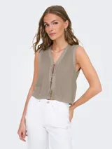 Chaleco de punto color beige, sin mangas, con cuello en V y cierre frontal con lazos.