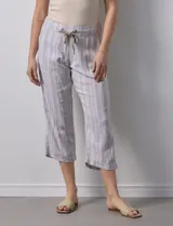 Pantalón capri de lino a rayas verticales en tonos grisáceos y beige, con cintura elástica y lazo ajustable.