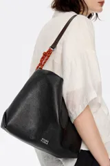 Bolso de mano negro marca Bimba y Lola, modelo Paper M, confeccionado en piel vacuna con estructura blanda. Incluye asa extraíble, bolsillo interior, etiqueta de tejido y logo metálico plateado.
