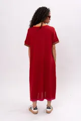 Vestido largo tipo remerón de manga corta, color rojo ladrillo con cuello redondo y puños en marrón.