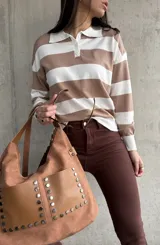 Buzo de tejido de punto color beige con rayas horizontales blancas, cuello polo con botones y mangas largas.