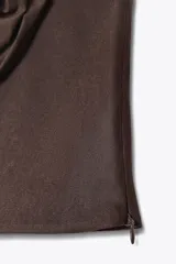 Top bandeau marrón de escote recto y hombros descubiertos, con detalle de flor en relieve en el delantero y cierre lateral con cremallera oculta.