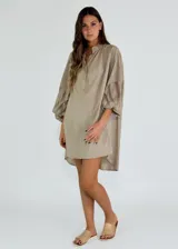 Vestido corto color ocre, con cuello mao, mangas largas abullonadas con detalle de encaje y corte evasé.