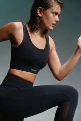 Top deportivo negro con breteles finos cruzados en la espalda y banda inferior con el logo de la marca Caro Cuore.