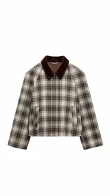 Chaqueta corta con estampado de cuadros en tonos beige y marrón, cuello marrón de pana, mangas largas y bolsillos laterales.