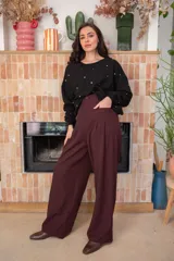 Sweater blanco de algodón con cuello redondo y mangas largas. Decorado con tachas plateadas en el frente y las mangas.