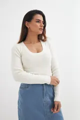 Sweater tejido de punto color crudo, con cuello redondo y mangas largas.