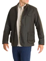 Chaqueta verde de tela canvas con tratamiento de cera Wax, cuello de cotelé, cierre con botones, tres bolsillos frontales y dos interiores.