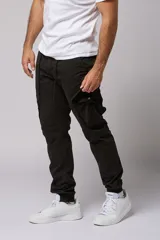 Pantalón cargo color beige de gabardina, con corte ajustado, bolsillos laterales con fuelle y puños elásticos en los tobillos.