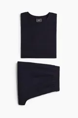 Conjunto de pijama corto de dos piezas. Remera negra de punto de algodón liviano con cuello redondo ribeteado acanalado, hombros caídos y bajo recto. Short negro en popelina de algodón con elástico revestido en la cintura, cierre de botón, bolsillos laterales y un bolsillo parche atrás.