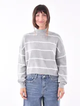 Polerón de tejido de punto color verde militar, con cuello alto y corte holgado.