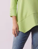 Blusa verde en tejido acanalado, marca Ruby Rd. Largo de mangas ¾ con abertura y botones. Terminación de ruedo asimétrico.