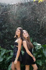 Vestido corto de lentejuelas color ciruela o morado oscuro, con escote corazón y detalle de argolla central que conecta con tirantes finos que atan al cuello. Presenta aberturas laterales (cut-outs) en la zona de la cintura y falda corta con vuelo.