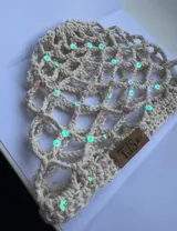 Gorro tipo mesh cap tejido a crochet en hilo color crema, con lentejuelas iridiscentes.