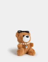 Llavero con dije de oso de peluche color marrón claro, con moño negro, collar de perlas y dije de corazón plateado.