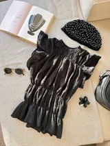 Casquete negro con apliques de perlas blancas.