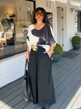 Pantalón palazzo negro de satén con cintura alta y lazo.