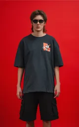Remera negra de manga corta con cuello redondo y calce oversize. Estampado frontal con Mickey Mouse en un diseño gráfico con detalles en naranja.