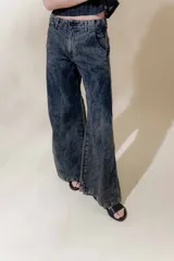 Pantalón de jean denim 100% algodón con tiro medio y piernas anchas, con 5 bolsillos y detalle de pespuntes a contra tono.