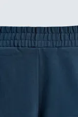 Bermuda azul petróleo de corte relaxed fit, confeccionada en algodón. Tiene cintura elástica ajustable con cordón, bolsillos laterales y un bolsillo trasero.