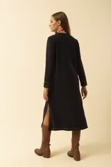 Vestido midi blanco de manga larga, con cuello redondo, bolsillo en el pecho y costuras a la vista.