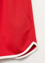 Short deportivo rojo con cintura elástica, terminaciones en contraste color blanco y dos bolsillos laterales.