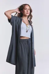 Camisola verde grisáceo de tencel con cuello camisero, mangas cortas con dobladillo y cierre frontal con botones.