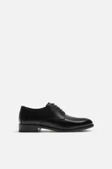 Zapato de vestir para hombre, tipo derby, color negro, con parte superior lisa, horma en punta y suela con ligero tacón.