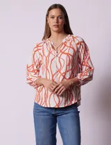 Blusa estampada blanca con diseño de cadenas y círculos color naranja. Cuello redondo con escote en V y lazo de ajuste. Manga 3/4.
