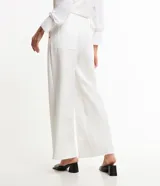 Pantalón pantalona de sastrería color blanco, con cintura elástica en la espalda, detalle metálico delantero y pliegues.
